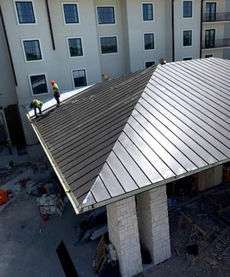 Crew installing standing seam metal roof panels on a commercial project in East Donegal